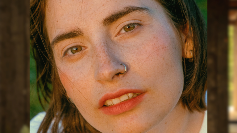 Close-up portrait in soft daylight showing natural skin texture and freckles