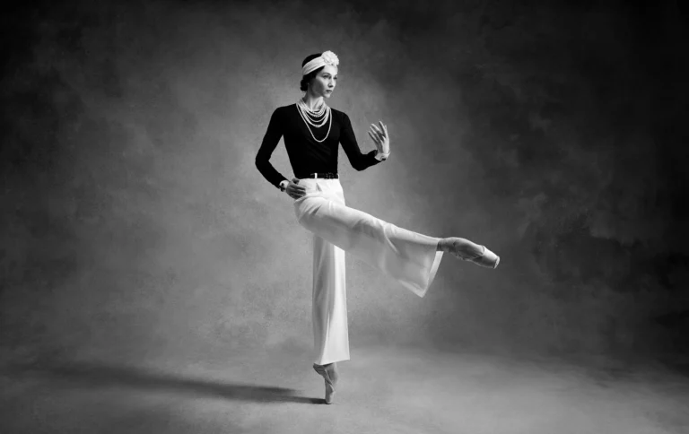 Black-and-white studio portrait of Svetlana Zakharova in a Chanel-inspired costume, posed en pointe with an extended leg.
